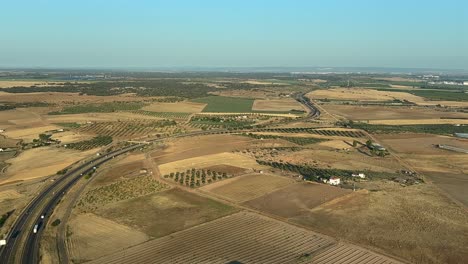 silhouette of a jet airplane over a highway and agriculture fields in badajoz, spain, shot from inside the cockpit in a real time flight arriving to the airport with the early morning light