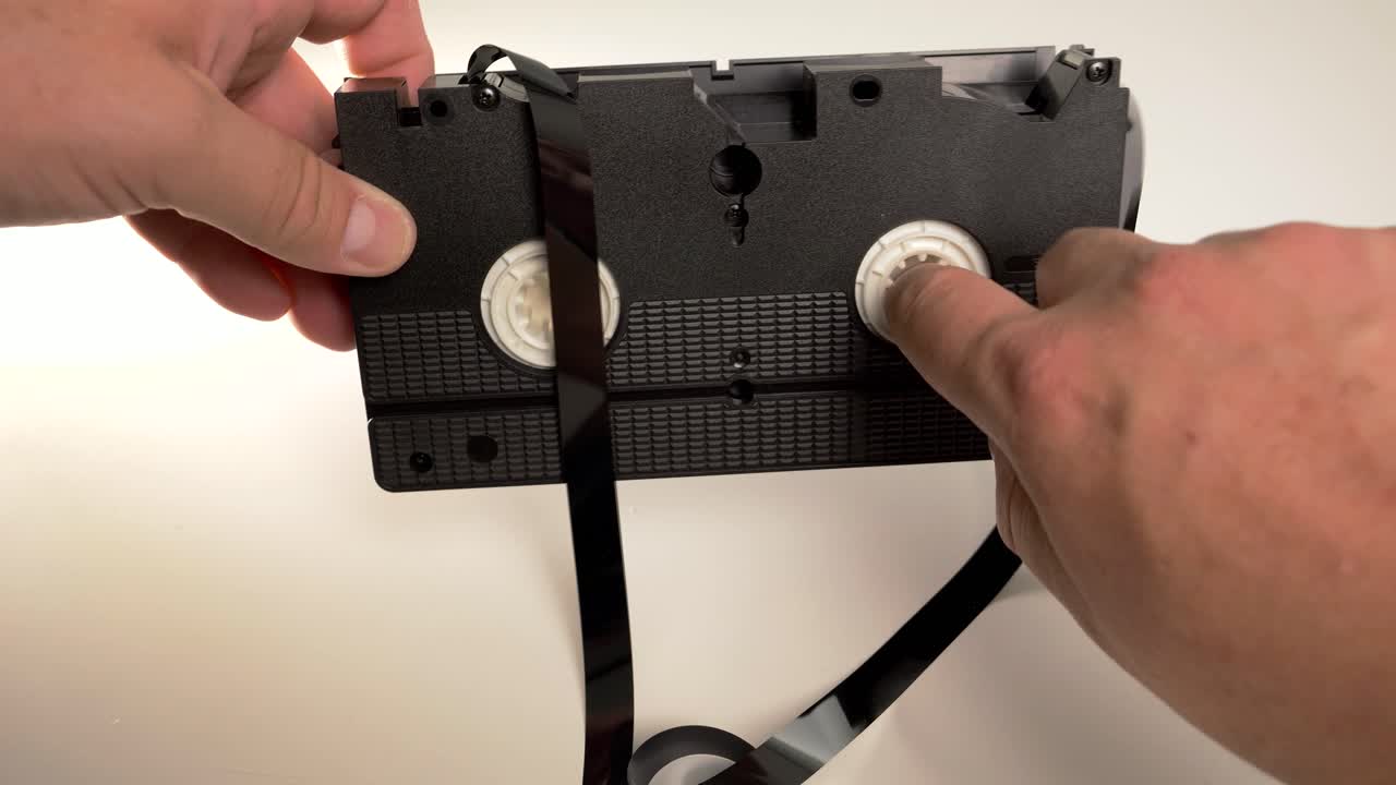 카세트 내부의 릴에 vhs 테이프를 수동으로 뒤집습니다.