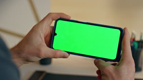 businessperson hands holding mockup cellphone working remote at office closeup