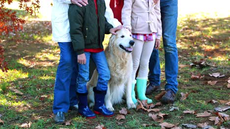 familia de pie en el parque con su perro