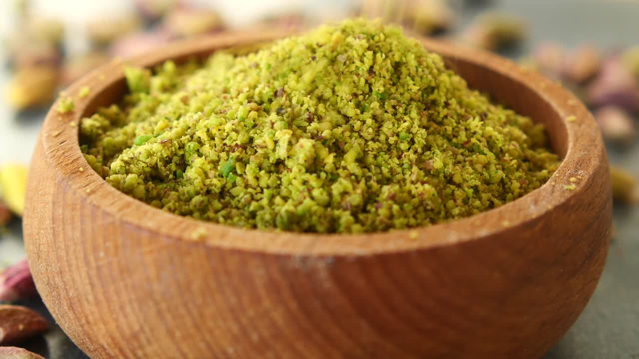 Close up of pistachio powder in a wooden bowl