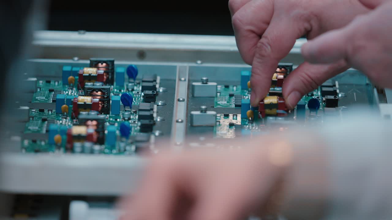 Hands assembling circuit boards in slow motion, tech focus