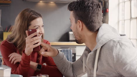 Pareja-Feliz-En-Casa-Usando-Teléfonos-Inteligentes-Juntos