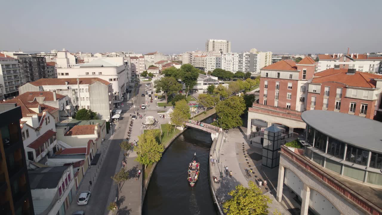 Skyline della città di Aveiro con un'enorme canoa turistica che naviga attraverso il canale del centro, vista aerea
