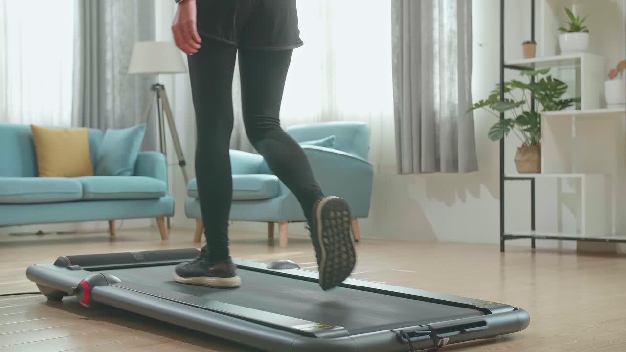 Back View Legs Of Asian Woman Training On Walking Treadmill At Home