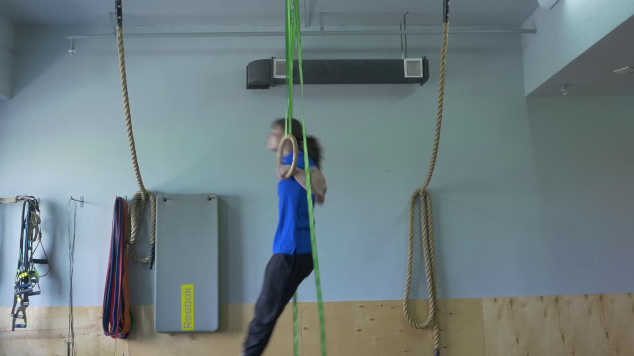 Person Performing Ring Exercises in a Gym
