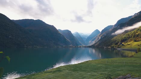 Die-Kamera-Schwenkt-Von-Links-Nach-Rechts-Und-Zeigt-Eine-Wunderschöne-Landschaft-Eines-Großen-Sees,-Der-Von-Bergen-Umgeben-Ist