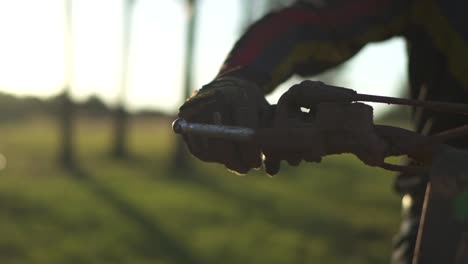 Man-hand-on-brake-handle-of-motocross-dirt-bike-motorcycle,-slow-motion-cinematic-close-up