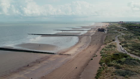 aerial view of people walking on the beach with breakwaters in cadzand, zeeland, the netherlands