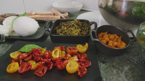 fresh ingredients for preparing traditional italian pizza on display over a marble countertop