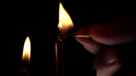 matchstick encendiendo la luz de las velas en fondo negro, cerrar la llama de las velas