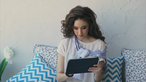 young woman using tablet on a couch