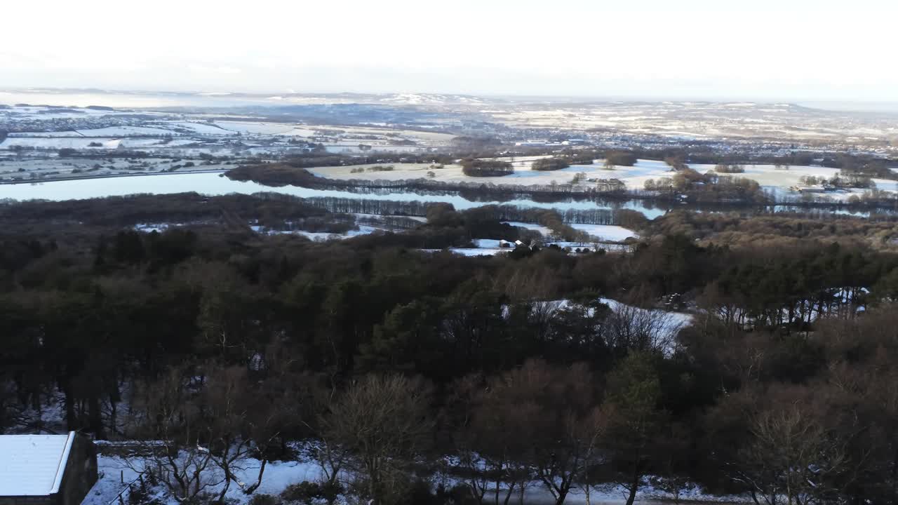 Snowy winter patchwork Lancashire farmland rural countryside landscape slow aerial pan left