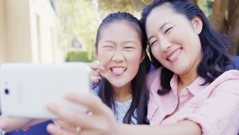 daughter and mother taking selfie with mobile phone 4k