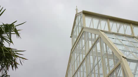 vista angular de un invernadero en los jardines botánicos de dublín con cielos nublados