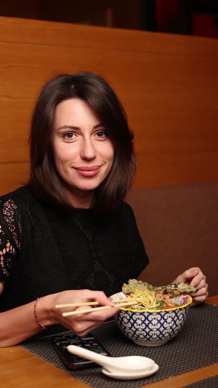 mujer comiendo ramen en un restaurante