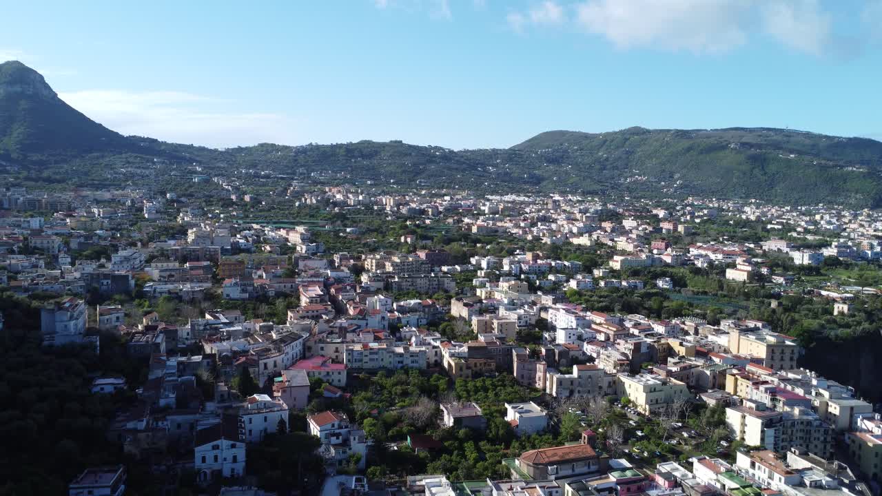 Vista de drone sobre os telhados de Meta, Itália, com montanhas ao fundo.
