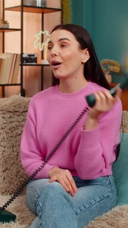 Young woman talking on retro 90s telephone making funny faces unwilling annoyed conversation mood