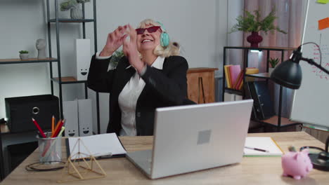 feliz mujer de negocios senior bailando baile de victoria celebrando fin de semana vacaciones éxito ganar en la oficina