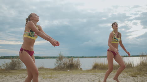 women pro beach volleyball team are playing in championship sportswomen are dressed sporty bikini jumping and attacking