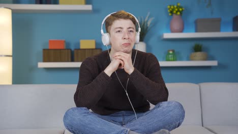 unhappy teenager is alone at home and listening to music.
