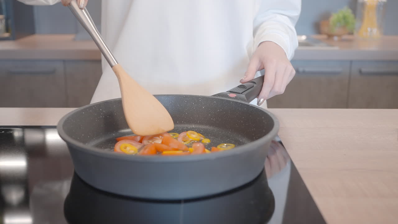 mujer cocinando verduras en una sartén