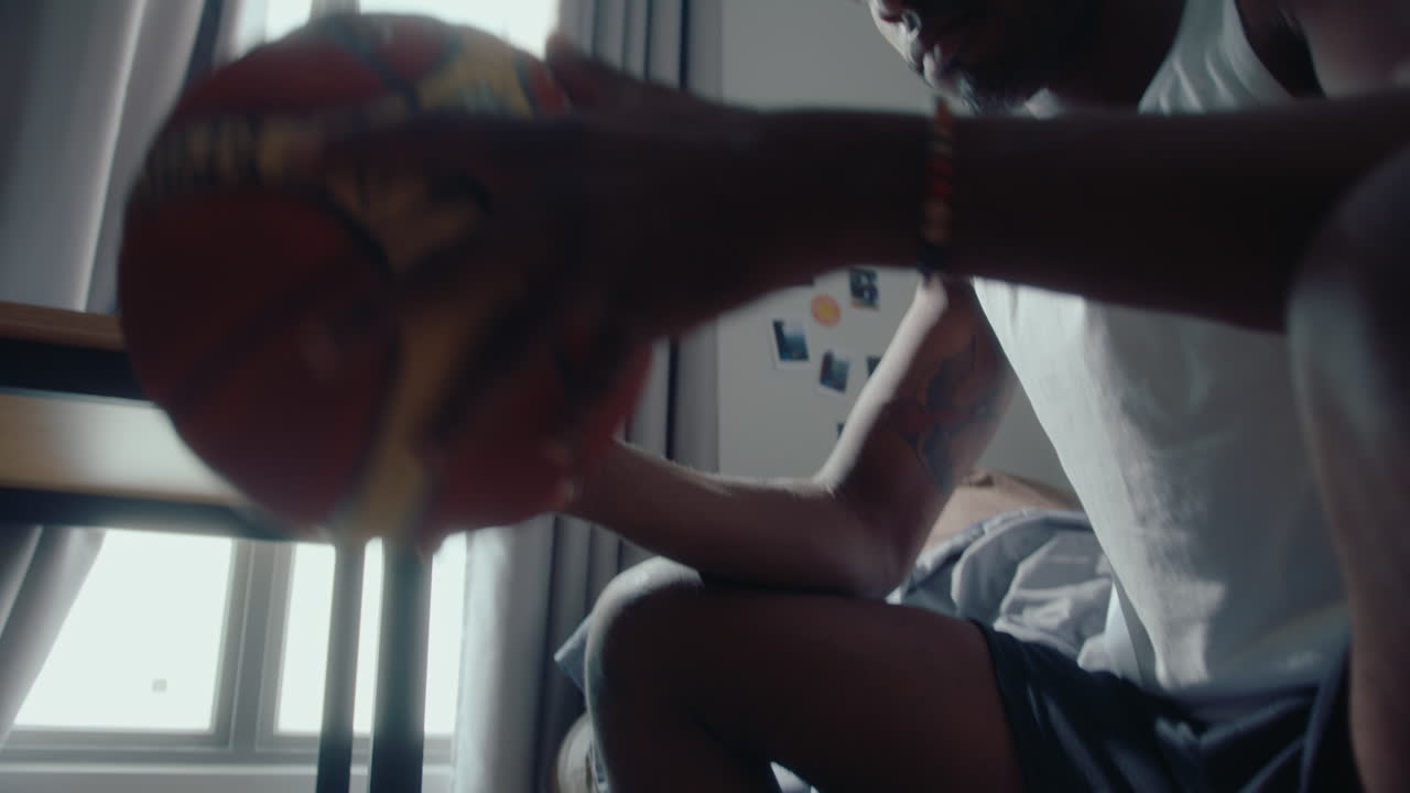 Young Black Man Arm Rolling with Basketball at Home