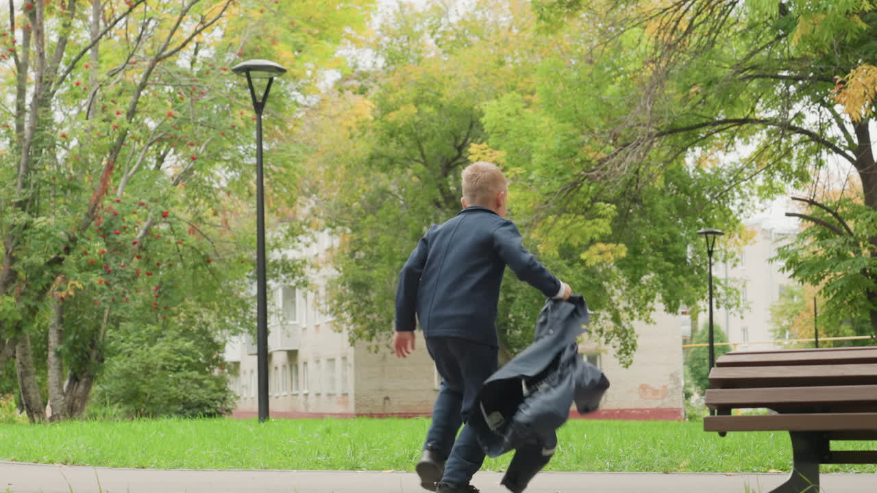 Youth confidently departs. Young man readies to exit confidently. Boy in white strides towards bench with confidence. Selfassured young person makes confident move towards leaving area