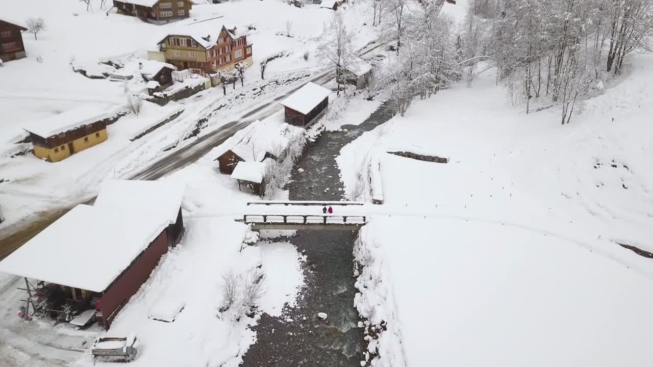 다리 위에 서 있는 두 사람, 드론이 날아간다