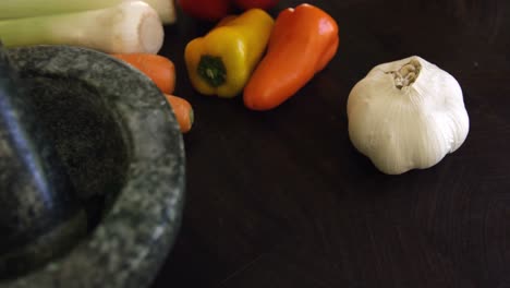 Mortar,pestle-and-vegetables-on-kitchen-worktop