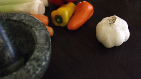 mortero, pestillo y verduras en la encimera de la cocina
