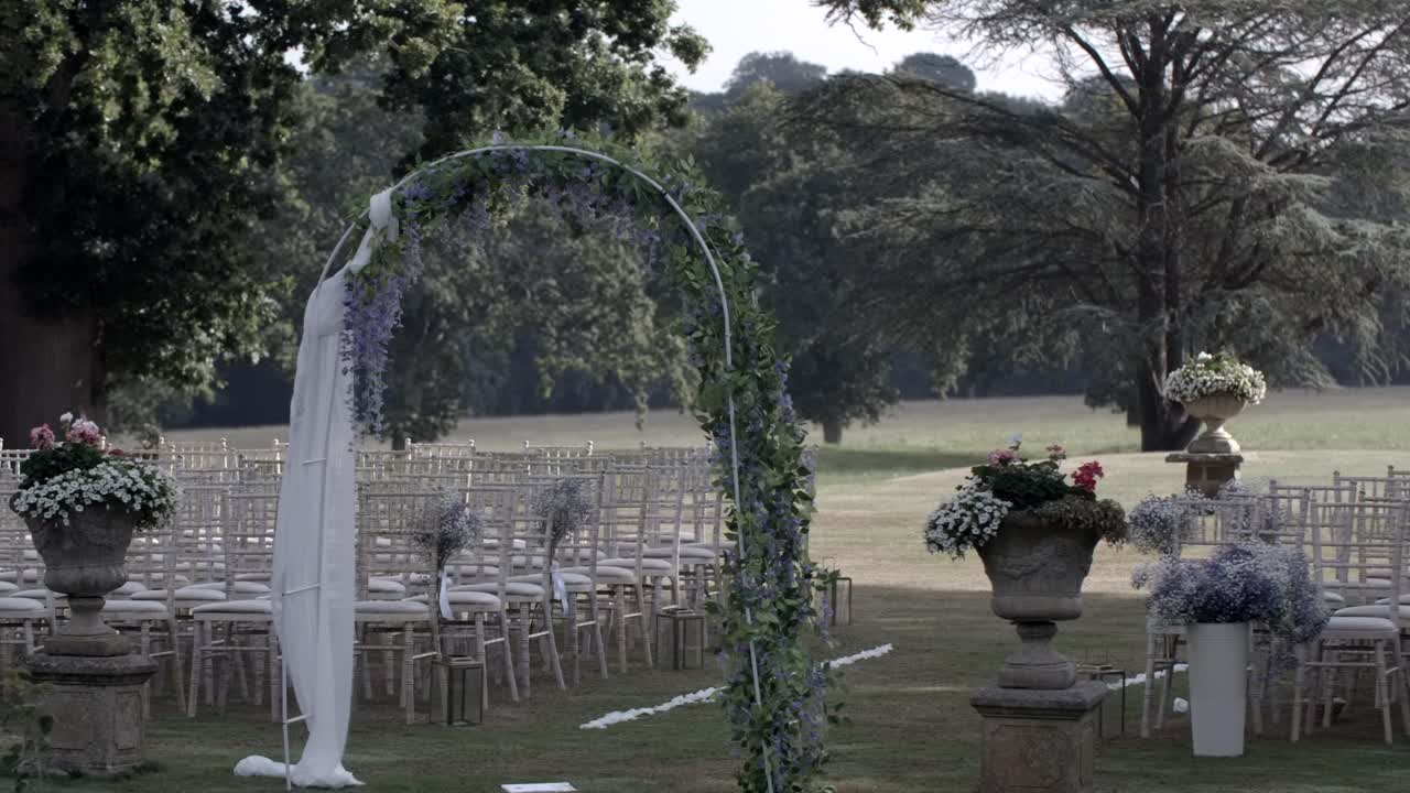 arco de bodas al aire libre y filas de sillas en un entorno pastoral