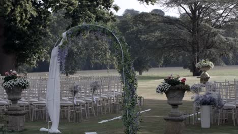 Outdoor-wedding-arch-and-rows-of-chairs-in-a-pastoral-setting