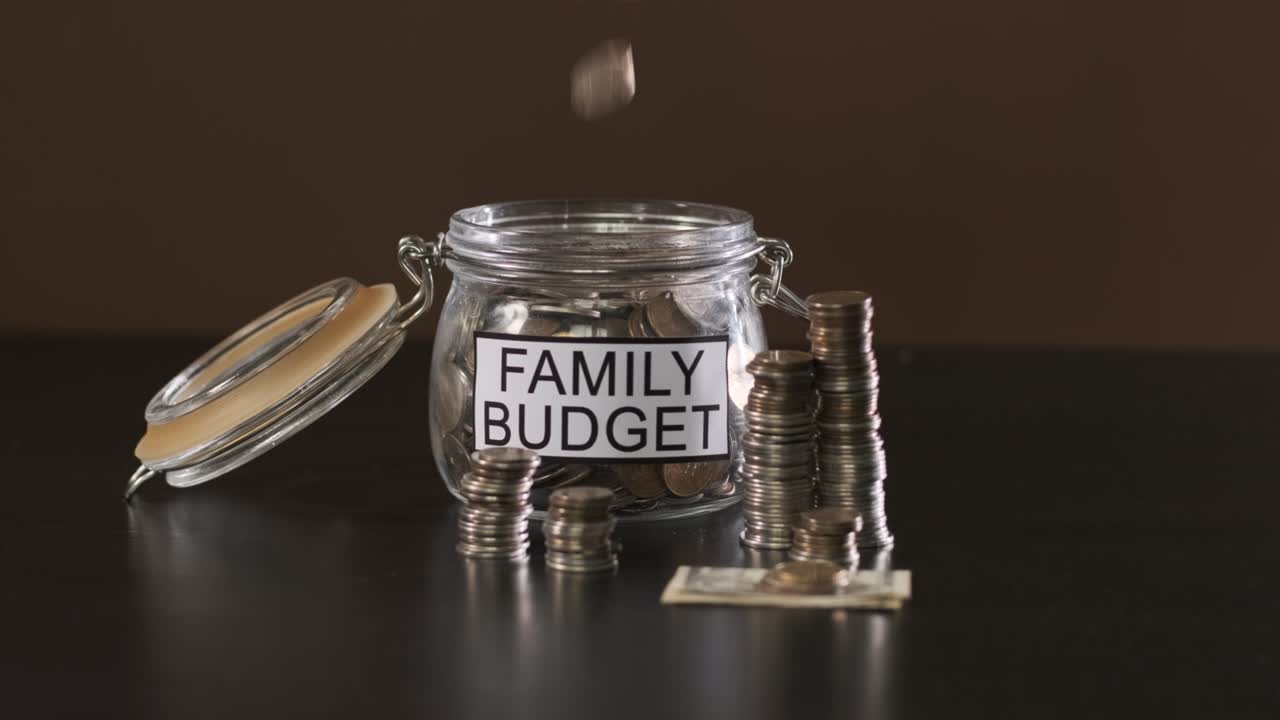 Man Putting Money into Glass with Family Savings