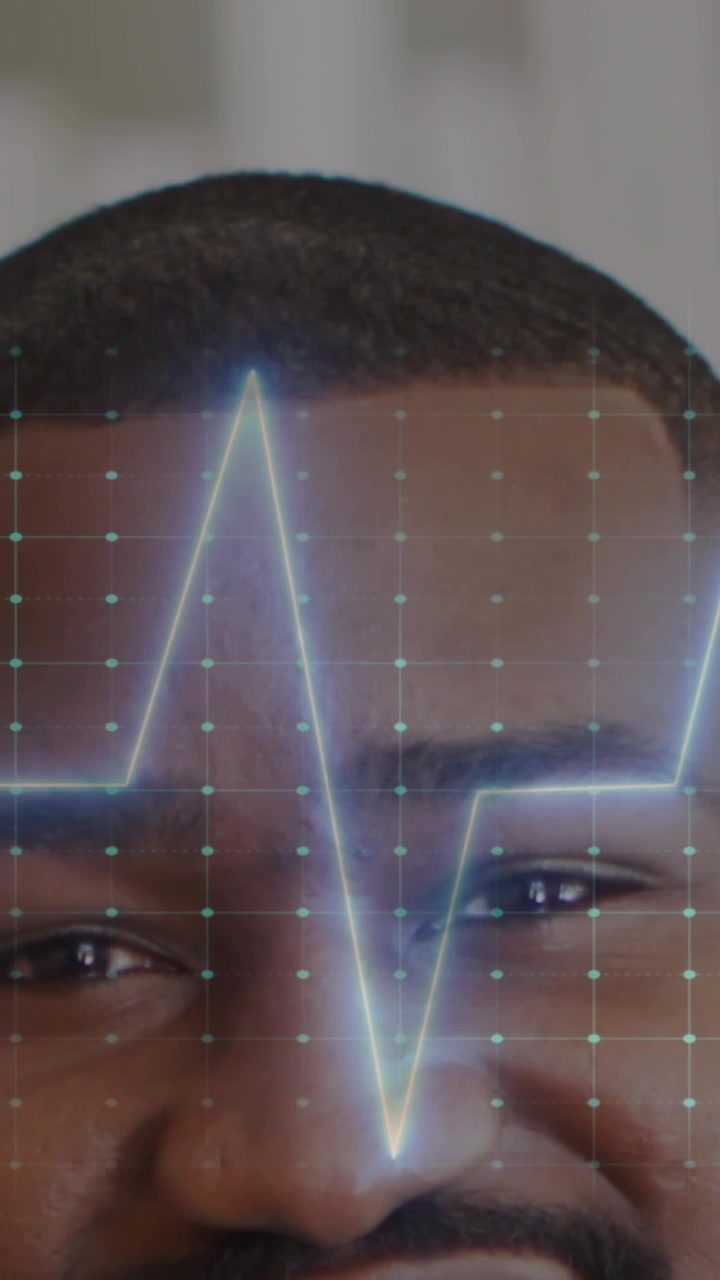 Animation of heart rate monitor against half face portrait of african american male doctor smiling