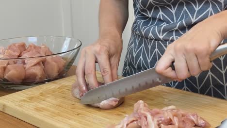 mujer cortando pollo