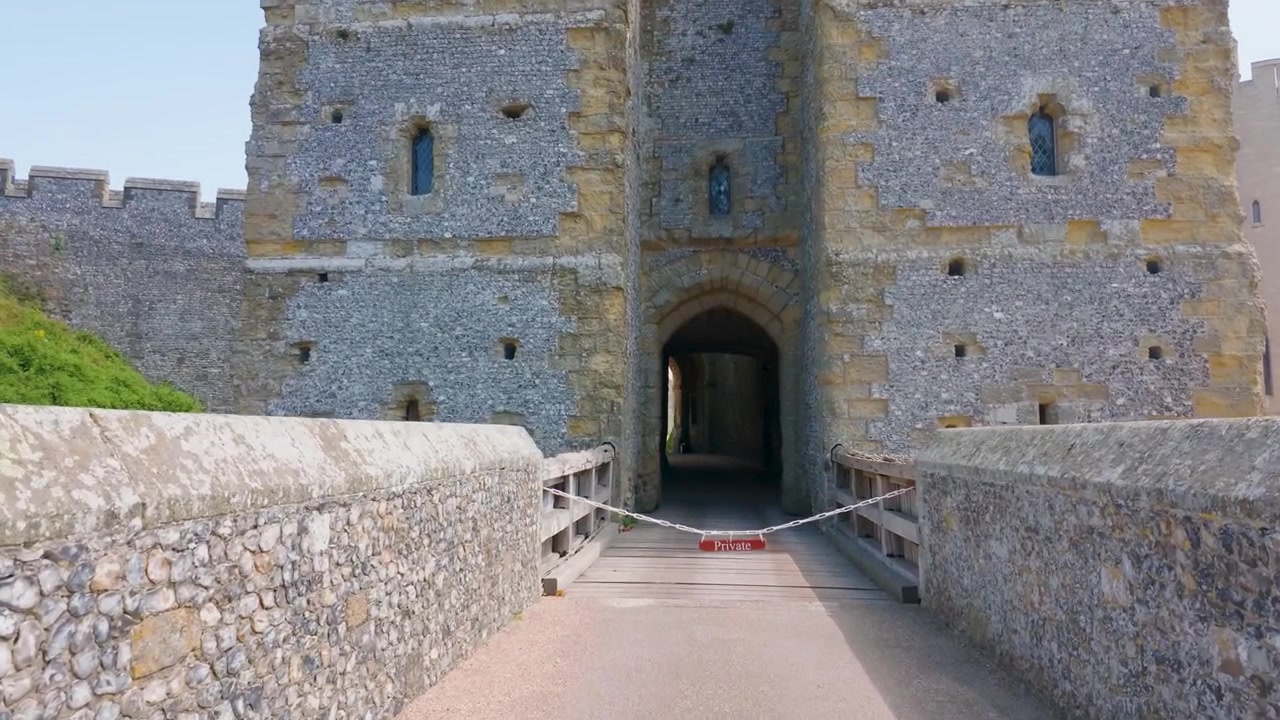 Placa de propriedade privada bloqueia a entrada no Castelo de Arundel enquanto a câmera se aproxima de uma barreira acorrentada na ponte, negando aos visitantes acesso à passagem restrita da portaria e à área proibida.