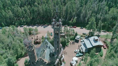 drone view of a castle like building in the middle of the forest in colorado