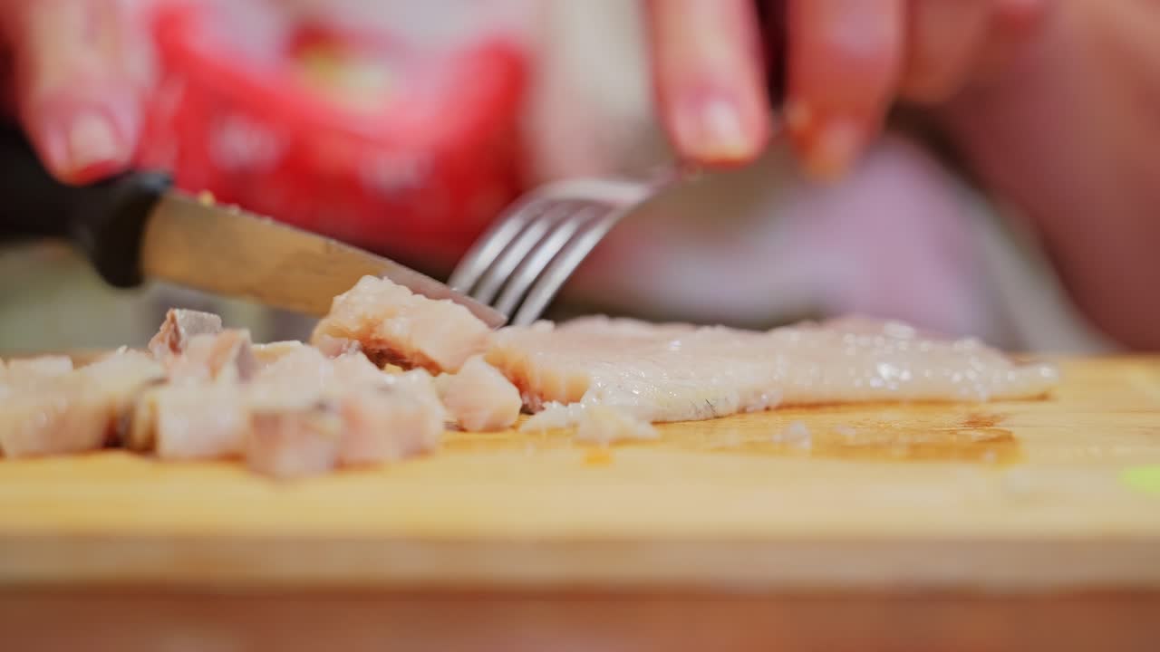 Chopping pickled herring on board highlights flavor tradition in Baltic cuisine culture