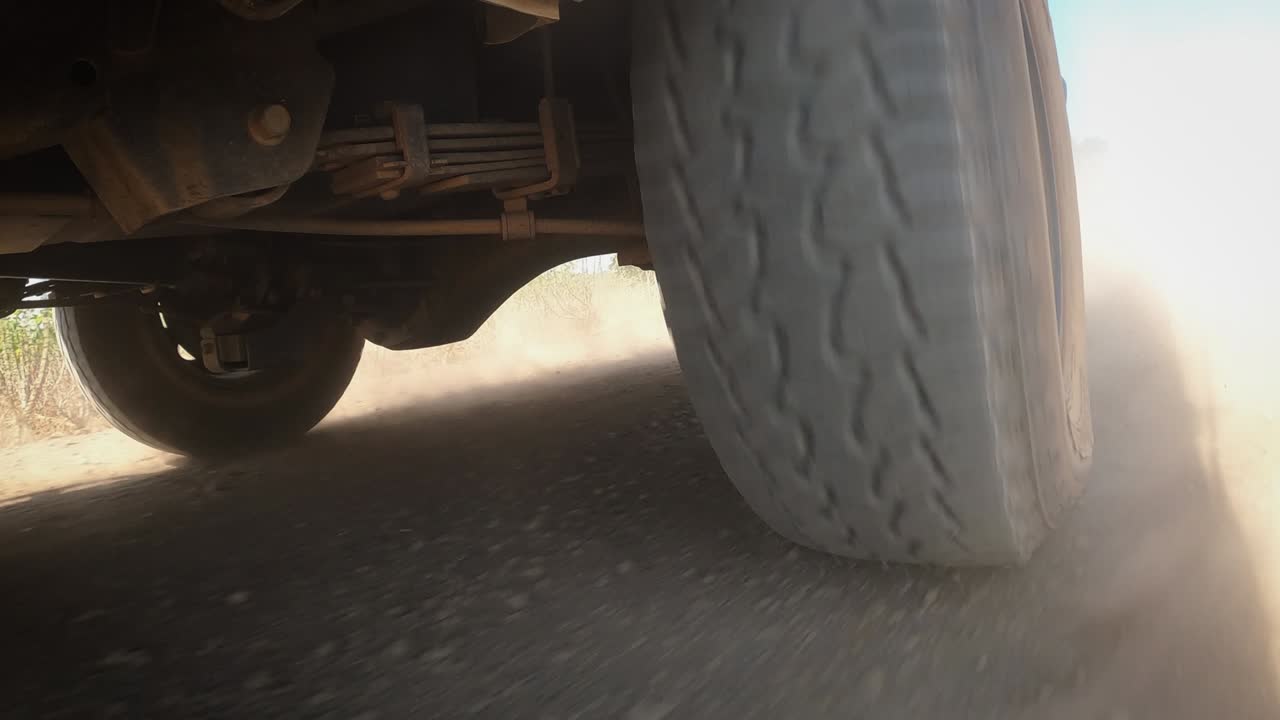 el sistema de transmisión de las ruedas traseras del camión ligero de tracción fuera de carretera de 4 ruedas que conduce en terreno sucio y polvoriento