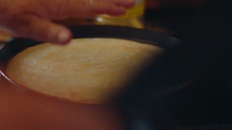 carefully and with motherly love, a pancake is turned over in a hot pan