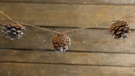 nieve cayendo con la decoración de cono de pino de navidad