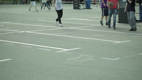 teenagers playing basketball in a city park