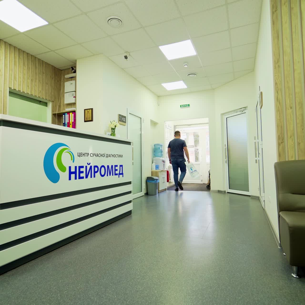 Man in private hospital. Patient goes from the doctor's cabinet and takes his results at the receptionist's. Health care concept.