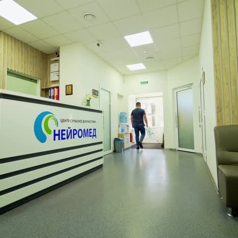 man in private hospital. patient goes from the doctor's cabinet and takes his results at the receptionist's. health care concept.