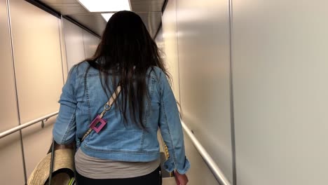 female walking down a airport jetway to a departing airplane, slow motion shot
