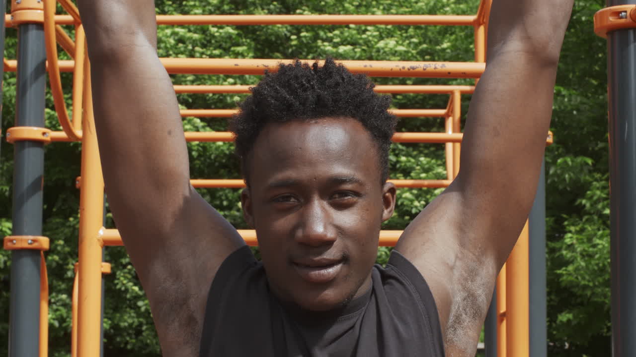 hombre haciendo pull-ups en un parque