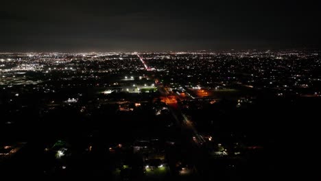 san bernardino county california at night with bright city lights and moving traffic aerial static