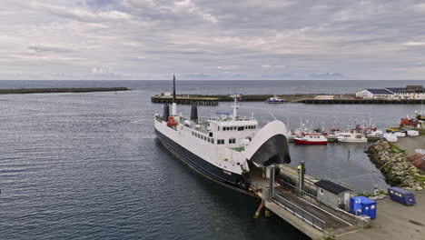 andenes noruega v5 entrada de agua de sobrevuelo de drones de bajo nivel capturando transbordadores y barcos de pesca atracados en el puerto junto a las instalaciones de procesamiento y fabricación de pescado - filmado con cine mavic 3 - junio de 2022