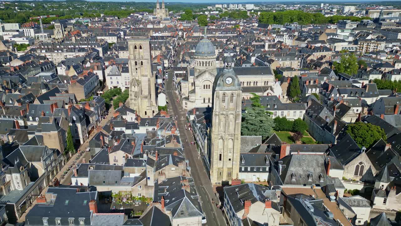 Aerial establishing of Basilique St Martin in Tours city on a sunny day with surrounding rooftops, push in descend